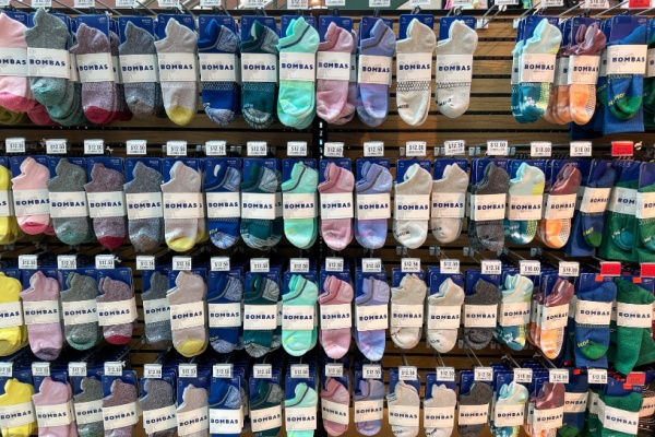 rows of Bombas socks hanging in retail store