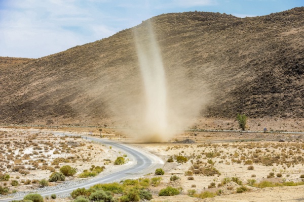 A large dust devil whips up in open southwest countryside