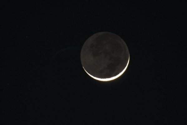 A nighttime view of a Crescent Moon and Earthshine