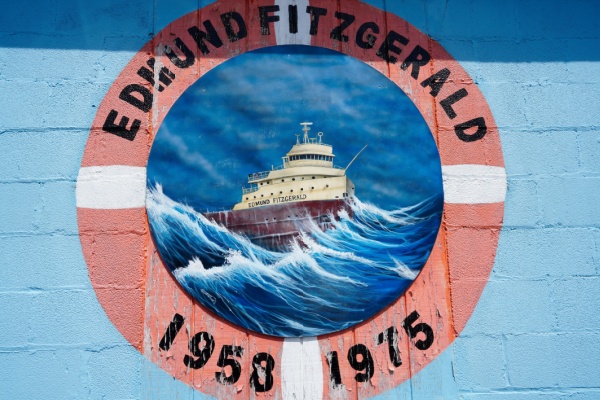 Painting memorializing the Edmund Fitzgerald in large waves, surrounded by words Edmund Fitzgerald 1950-1975