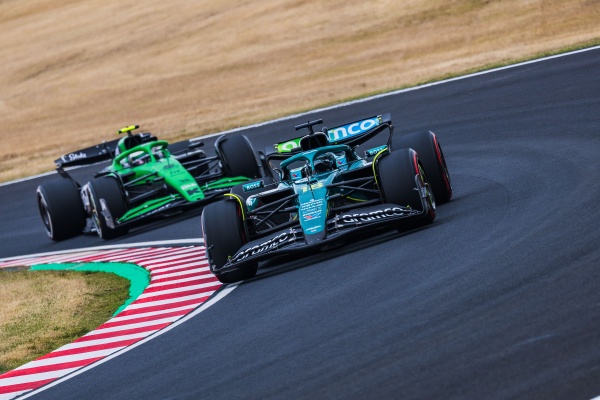 2 F1 cars round the turn on Japanese speedway