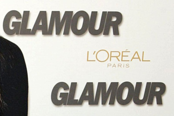 Glamour magazine and L'Oreal logos on backdrop at event
