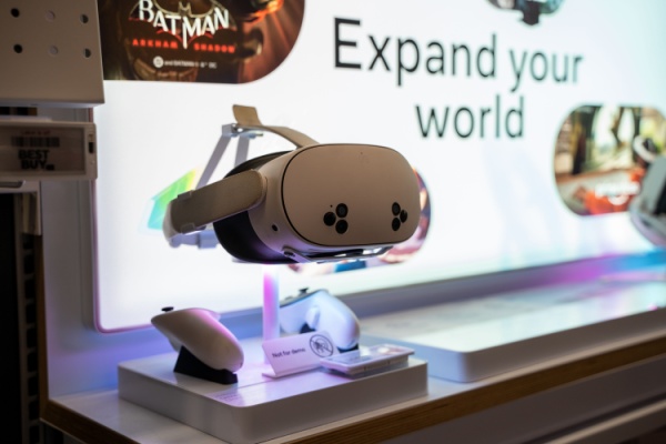 Meta VR Headset hanging on display above hand controllers