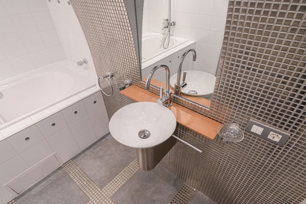 Modern bathroom with brown mosaic tile on walls and mosaic tile mixed with larger tiles on floor