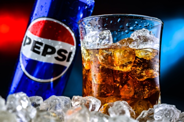 Pepsi can next to glass of Pepsi on ice
