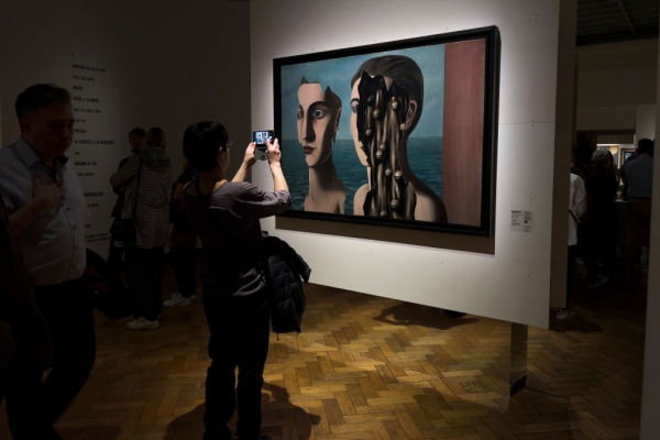 Art museum visitor takes photo of surrealist Rene Magritte painting
